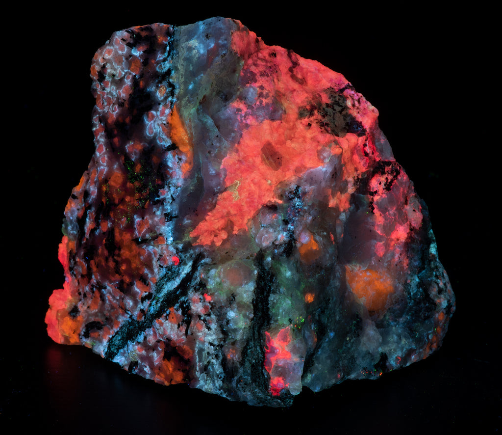 A fluorescent mineral specimen of tugtupite and sodalite