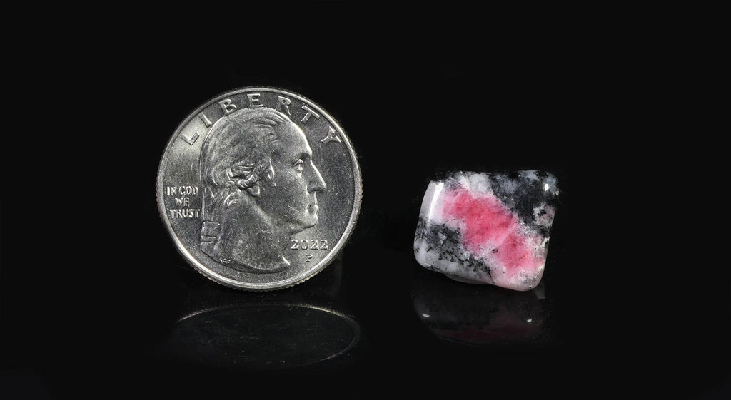 A tumbled piece of tugtupite showing tenebrescence