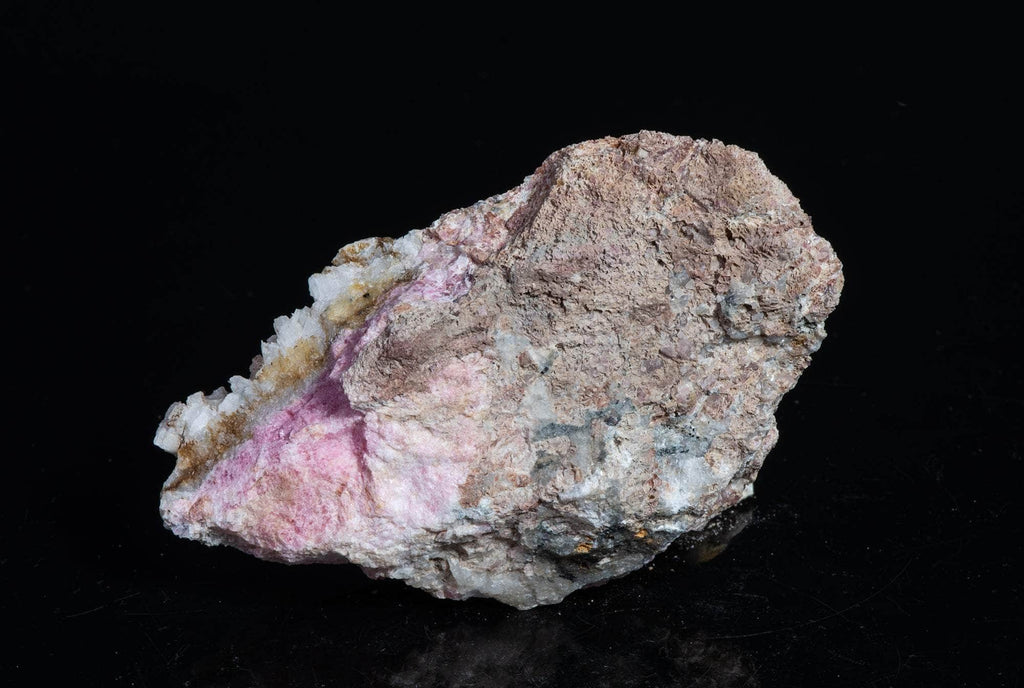 A smaller piece of our larger Kangerlussaq tugtupite specimens containing small tugtupite crystals dispersed throughout the matrix. 
