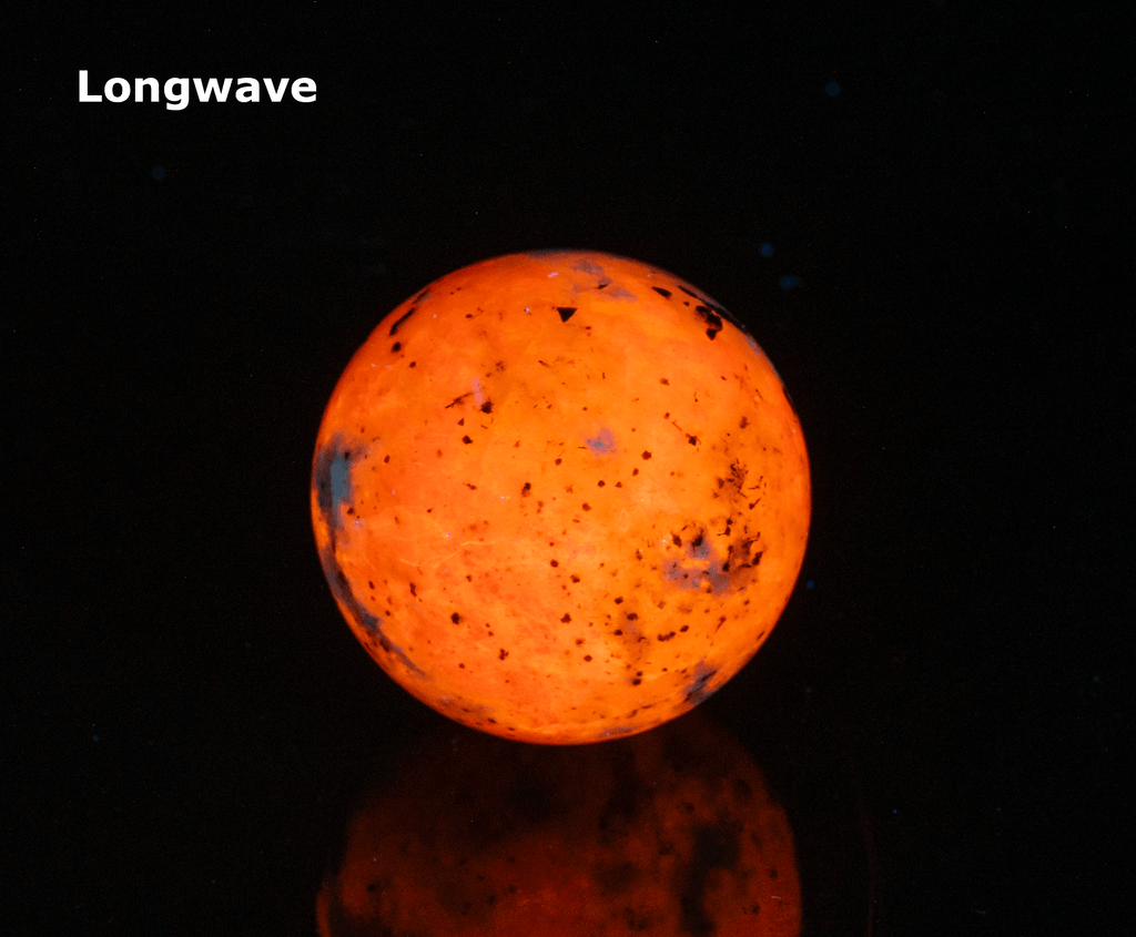 An incredibly bright and colorful, fluorescent sodalite sphere from Greenland