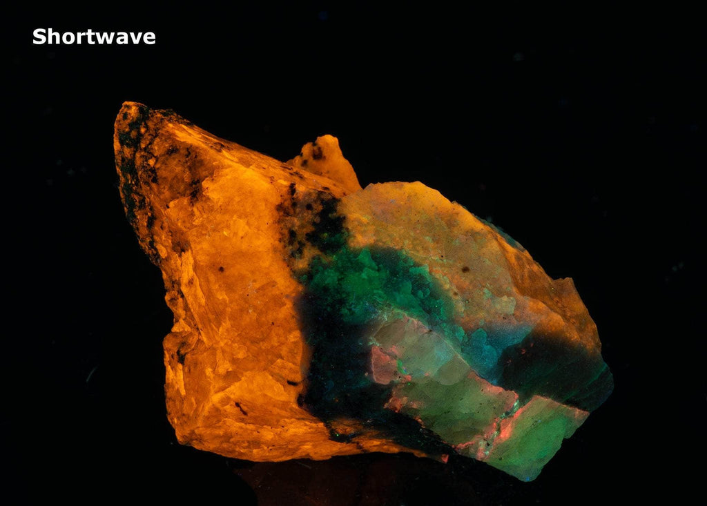 A mix of non-fluorescing ussingite and bright fluorescent sodalite, minor tugtupite from Greenland.