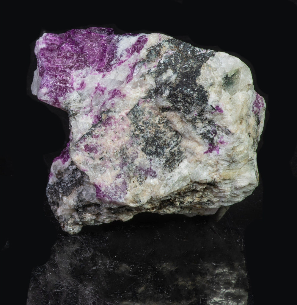 A large mineral specimen of fluorescing sodalite shown under all wavelengths