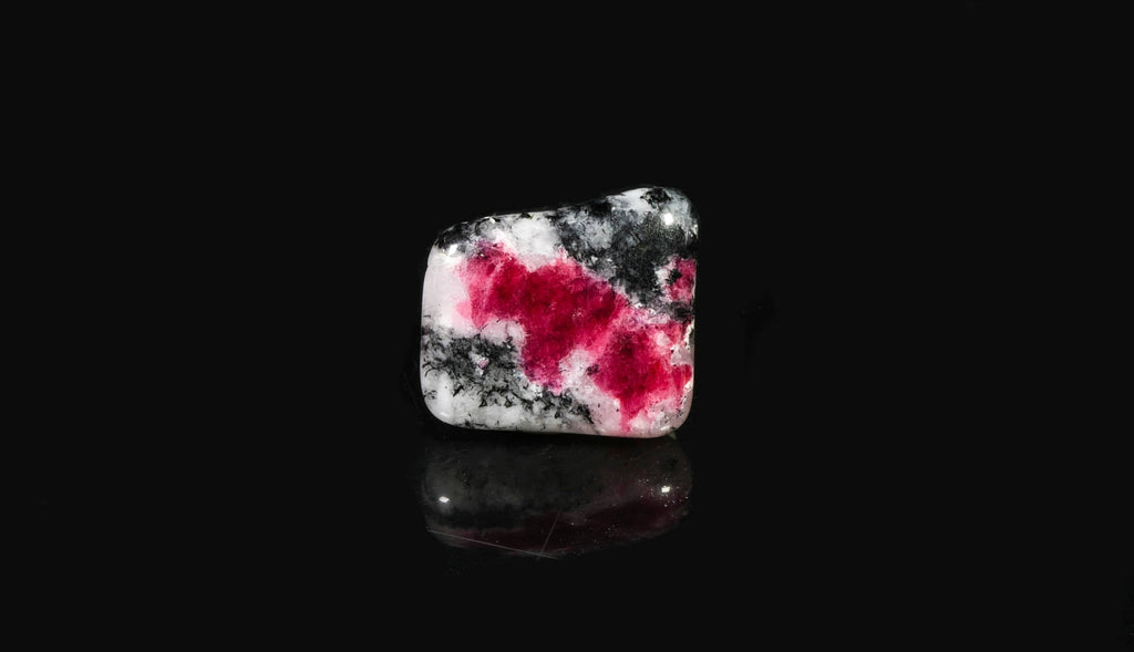 A tumbled piece of tugtupite showing tenebrescence