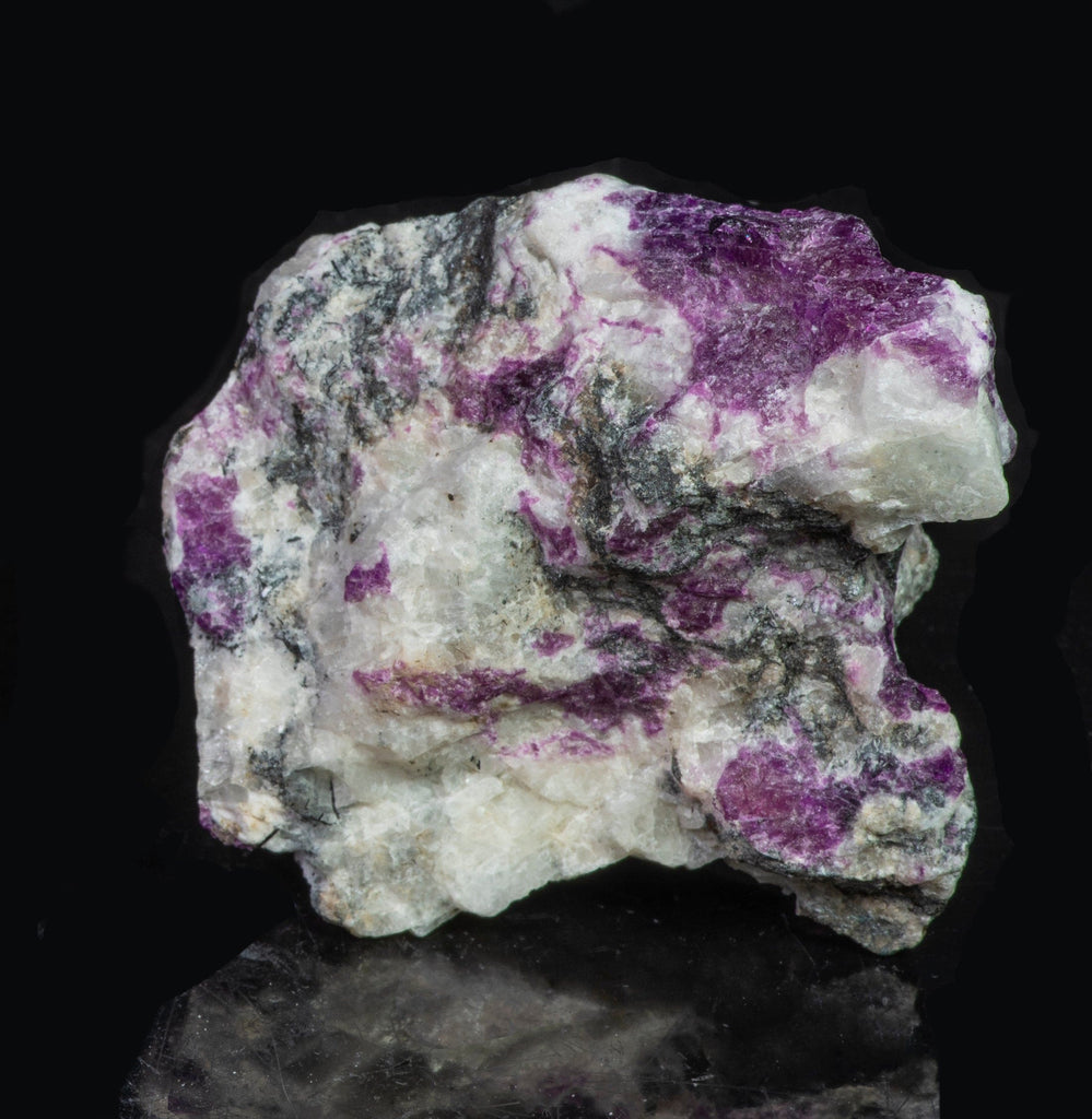 A large mineral specimen of fluorescing sodalite shown under all wavelengths