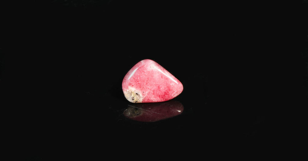 A piece of tumbled tugtupite showing tenebrescence