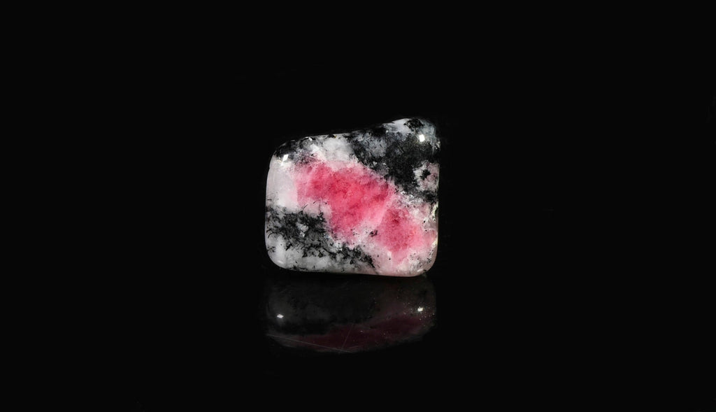 A tumbled piece of tugtupite showing tenebrescence