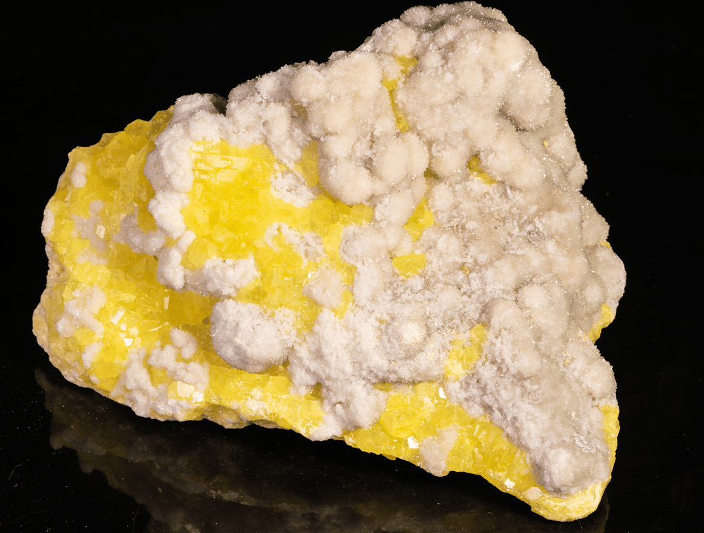 Yellow sulphur crystals sit atop an aragonite matrix