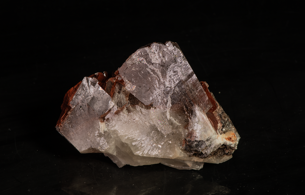 Reddish-brown chocolate calcite brightly fluorescing a red and purple under shortwave UV with excellent zoning