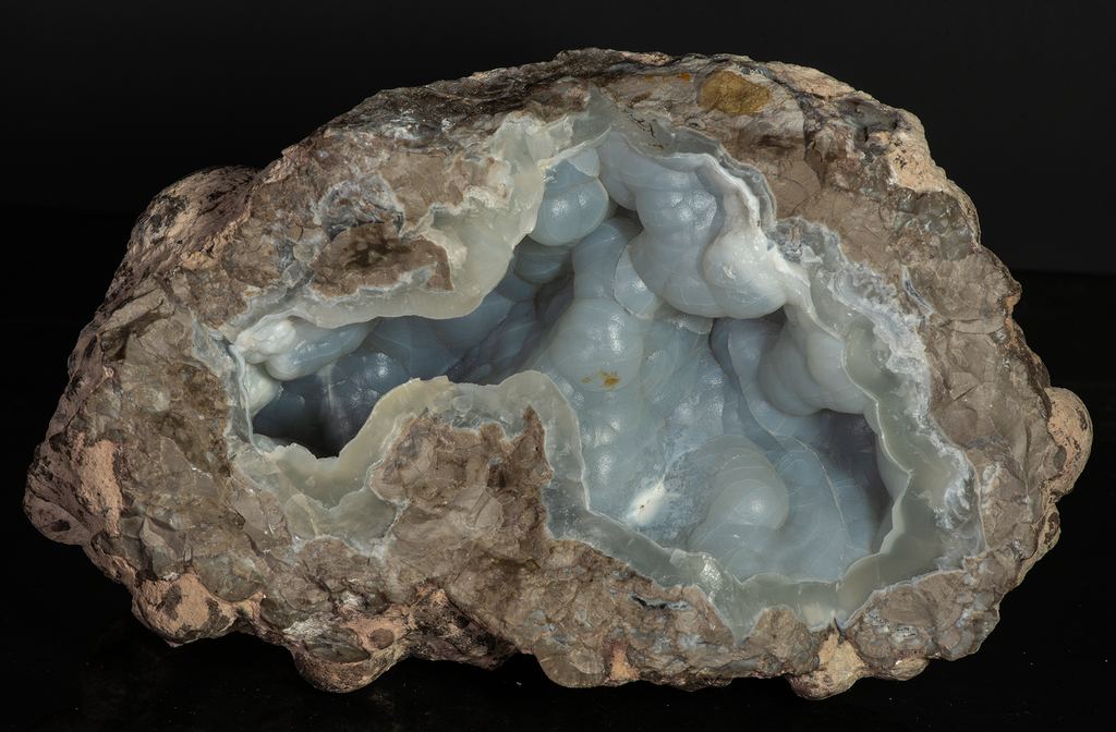 A huge half geode with botryoidal chalcedony crystals inside. It fluoresces a bright green under UV light