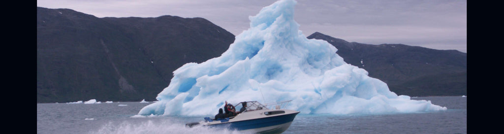 boat in front of iceberg