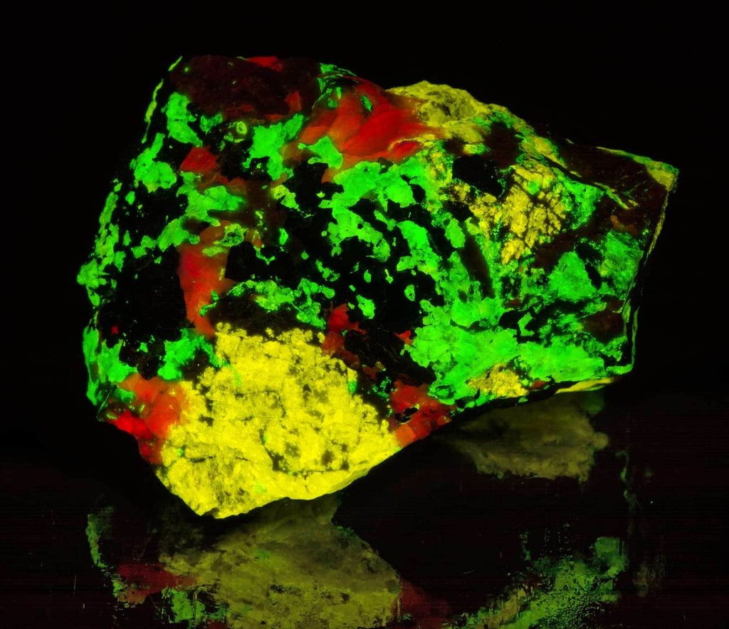 A piece of esperite, willemite, calcite under shortwave UV light from franklin mine, new jersey