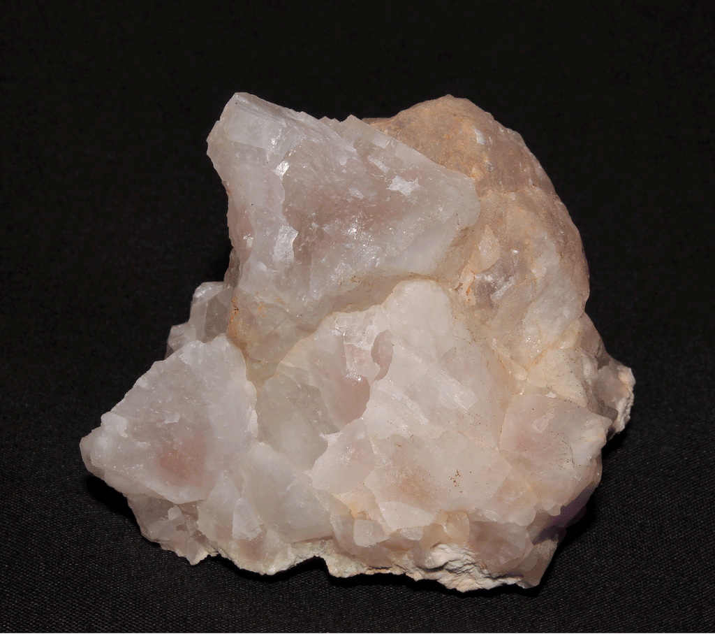 A fluorescing mineral under white light, shortwave UV light and longwave UV light