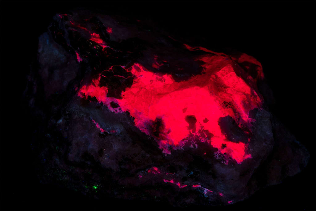 A piece of gemmy tugtupite from Greenland under shortwave light