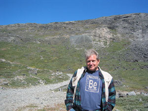 A man wearing a tshirt in front of a mountain