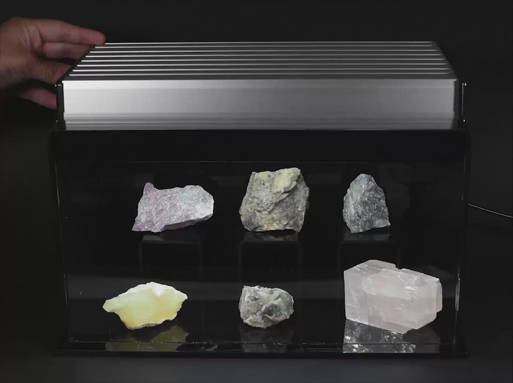 A video showing a mineral display in white light and longwave UV light
