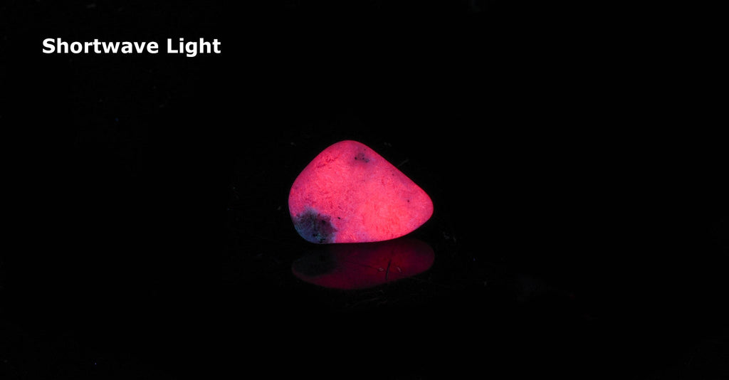 Bright red tugtupite fluorescing under UV light