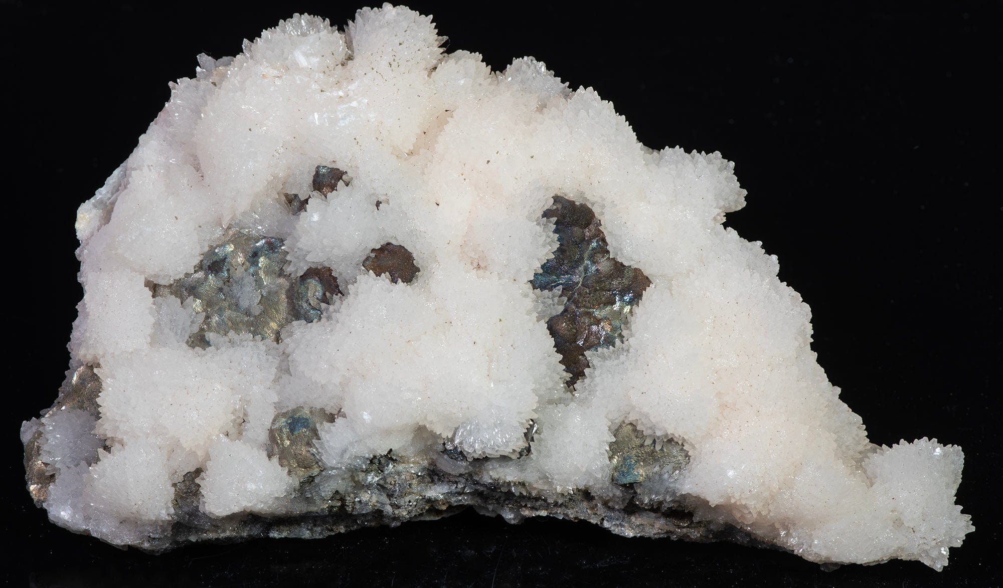 A mineral specimen of white calcite crystals and pyrite